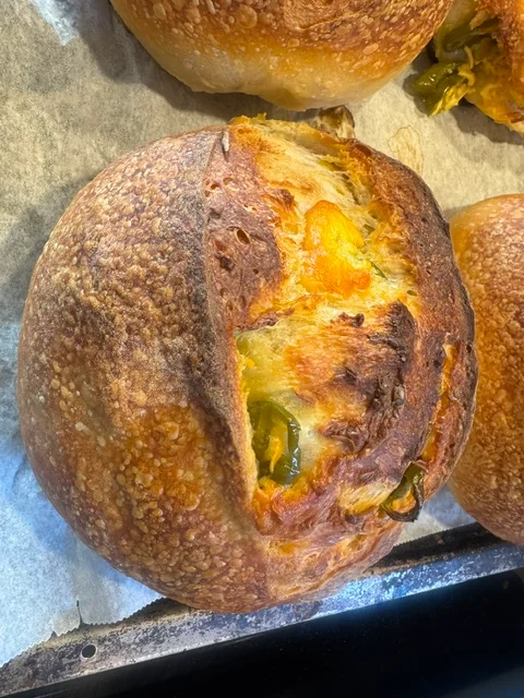 Brød med jalapeños og cheddar på et stekebrett.